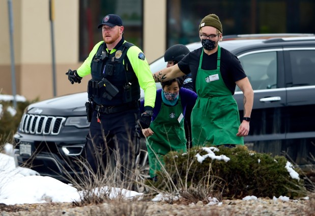 Logan Smith (right) and his co-worker are evacuated from the scene of a shooting at the King Soopers on Table Mesa Drive in Boulder on Monday, March 22, 2021. (Matthew Jonas/Staff Photographer)