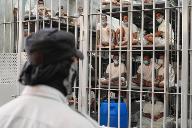 Prisoners look out from their cell at the Terrorist Confinement Center in Tecoluca, El Salvador, Friday, April 4, 2025, during a tour by the Costa Rica Justice and Peace minister. (AP Photo/Salvador Melendez)