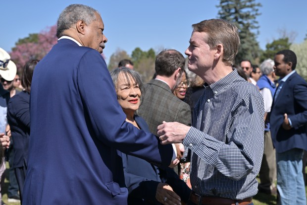 Former Denver Mayor Wellington Webb, left, and his wife Wilma talk with U.S. Sen. Michael Bennet, right, at City Park in Denver on Friday, April 11, 2025. (Photo by Hyoung Chang/The Denver Post)