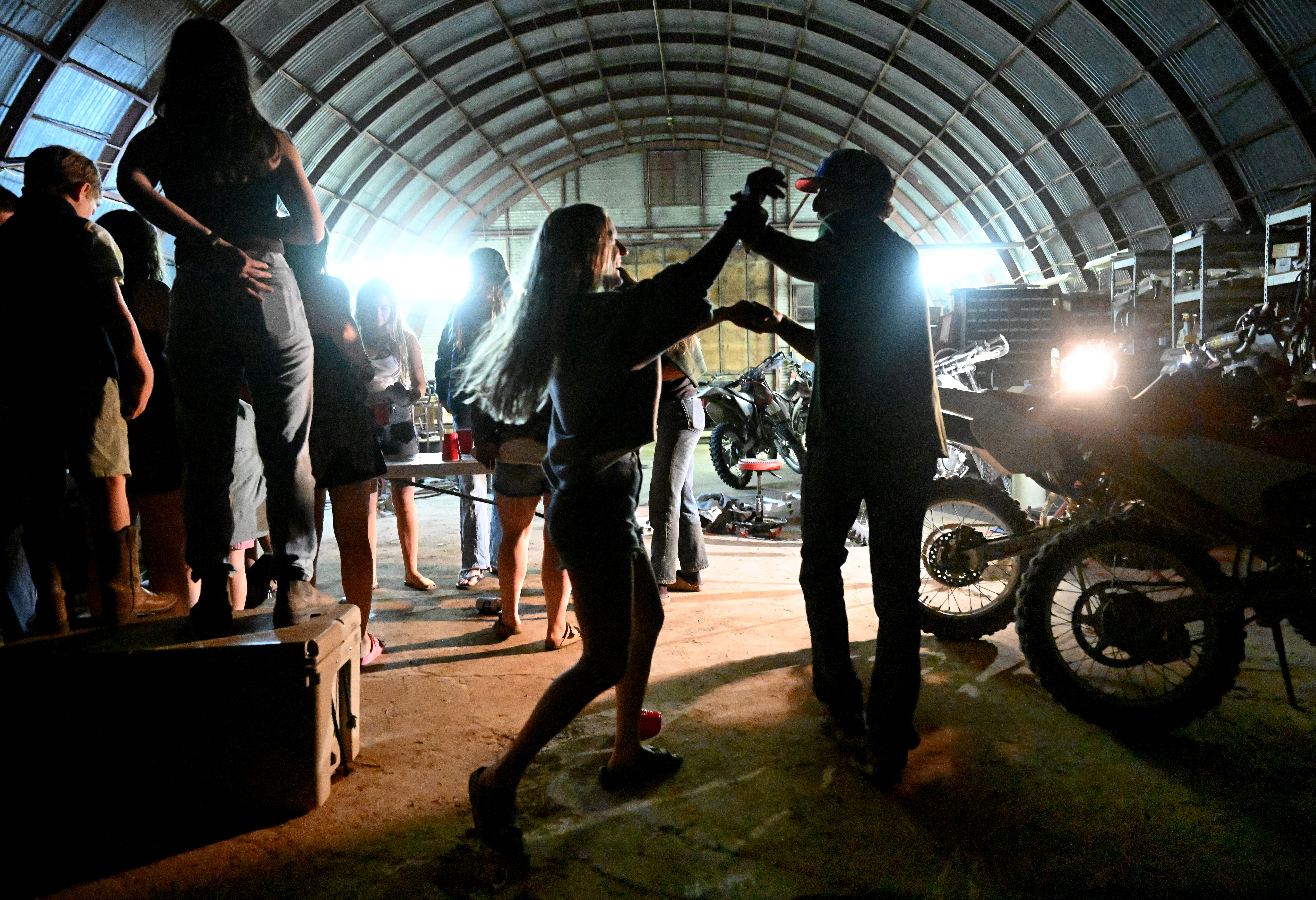 After a long day of branding cattle, and a heavy downpour, Claudia Landreville and her boyfriend, managing apprentice Mike Giordano dance to music in the barn near headquarters at Chico Basin Ranch on June 26, 2024. To celebrate and mourn their final large scale branding on the ranch, family, friends and neighbors joined together in an impromptu party to celebrate their 25 years on ranch. (Photo by Helen H. Richardson/The Denver Post)