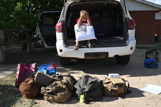 Woods Leach, 10, rests his head on his knees as he sits in the back of one of the family's cars as his parents pack up their home of decades at Chico Basin Ranch on June 26, 2024. (Photo by Helen H. Richardson/The Denver Post)