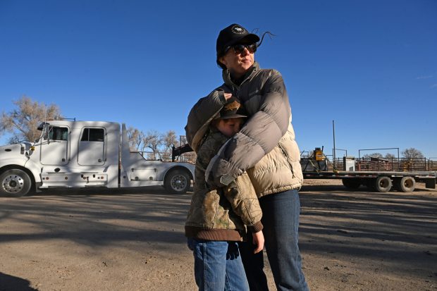 Tess Leach hugs her son Hayes, 8, as the final bull was loaded onto a large semi-truck to be sold on the family's final day at Chico Basin Ranch on Dec. 30, 2024. (Photo by Helen H. Richardson/The Denver Post)