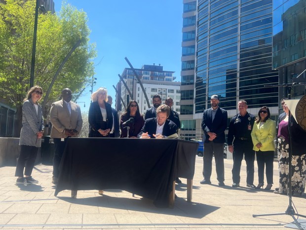 Denver Mayor Mike Johnston signs his first executive order during a press conference about the Denver Permitting Office at a new downtown location of the Urban Egg on Monday, April 14, 2025. (Photo by Elliott Wenzler/The Denver Post)
