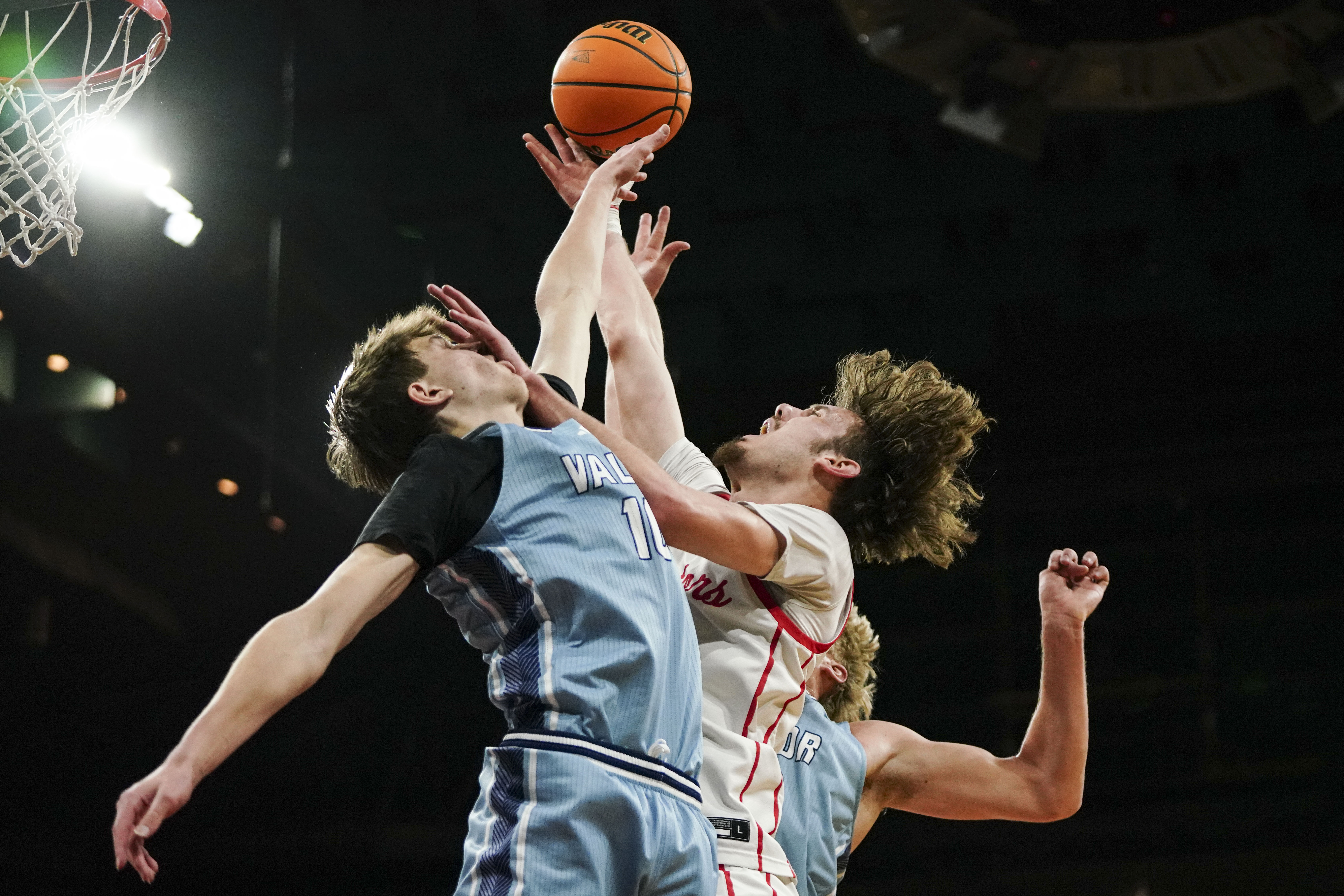 Eaglecrest's Garrett Barger (12) splits Valor Christian's Drake Bebout (10) and Brady Wynja (23) while shooting during the Class 6A Boy's Basketball State Championship game at Denver Coliseum, Saturday, March 15, 2025, in Denver. (Rebecca Slezak/Special to The Denver Post).